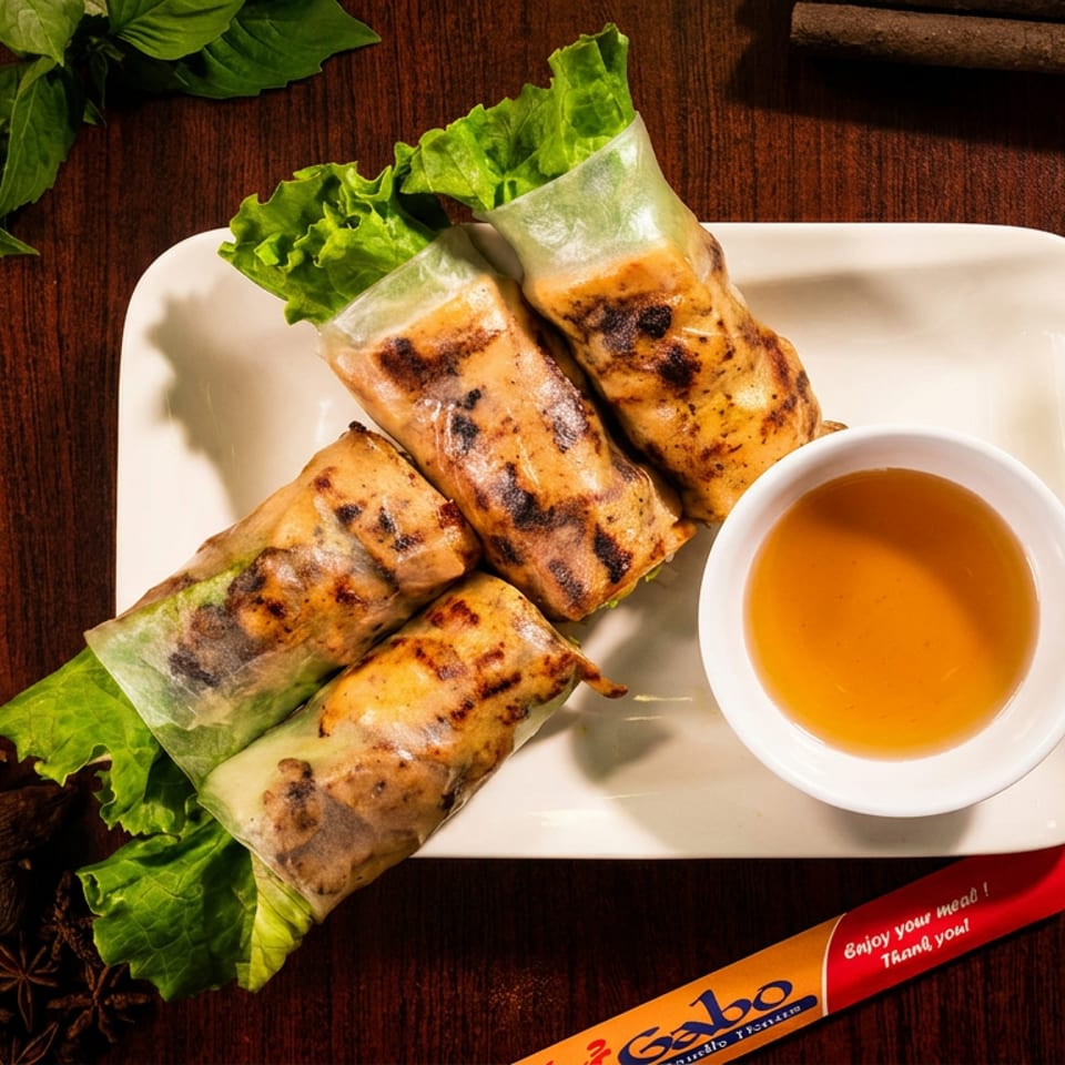 Grilled chicken spring rolls with lettuce, dipping sauce, and spices on a wooden table.